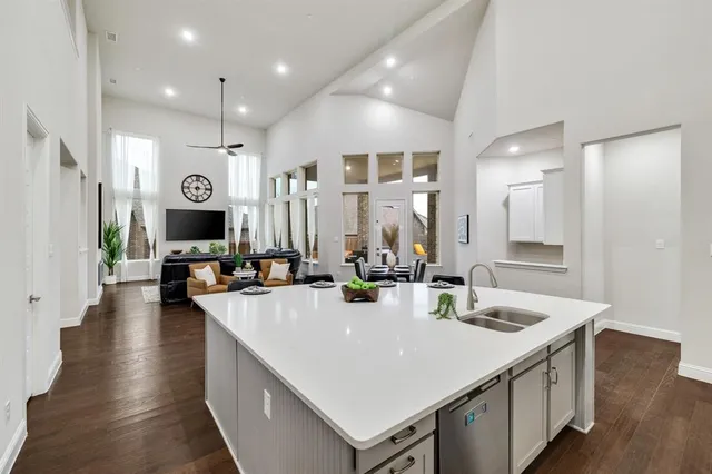 a large kitchen with sink a counter top space and stainless steel appliances