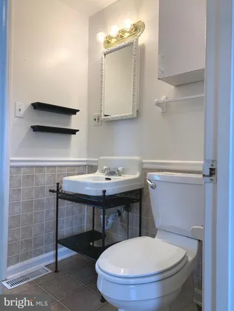 a bathroom with a sink a toilet and mirror