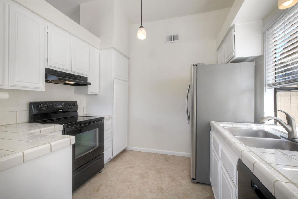 1394 Longfellow Road Vista, CA 92081 - Photo 18 of 50 a kitchen with stainless steel appliances granite countertop a sink stove and refrigerator