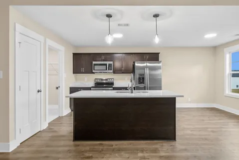a view of kitchen with stainless steel appliances granite countertop cabinets and wooden floor