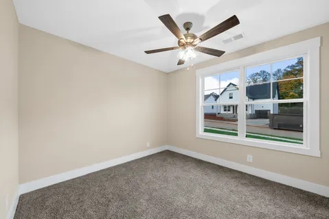 a view of an empty room with a chandelier fan