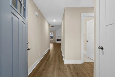 a view of a hallway with wooden floor and staircase