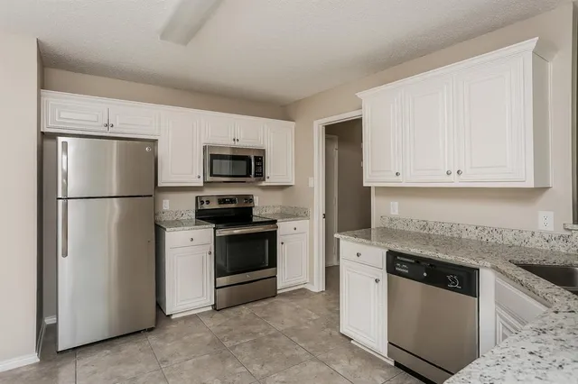 a kitchen with stainless steel appliances granite countertop a refrigerator stove a sink and dishwasher