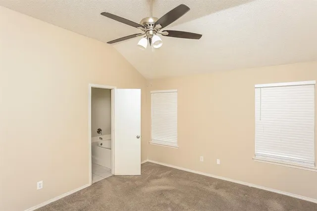 an empty room with a ceiling fan and a window