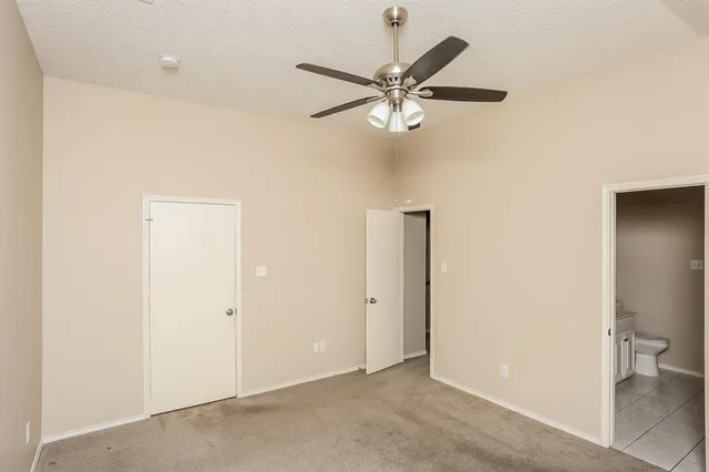 an empty room with a ceiling fan and a window