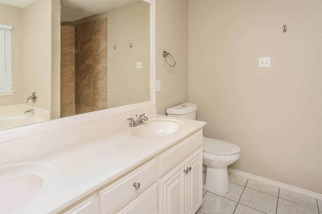 8009 Blue Duck Trail Arlington, TX 76002 - Photo 9 of 16 a bathroom with a sink a toilet and a mirror