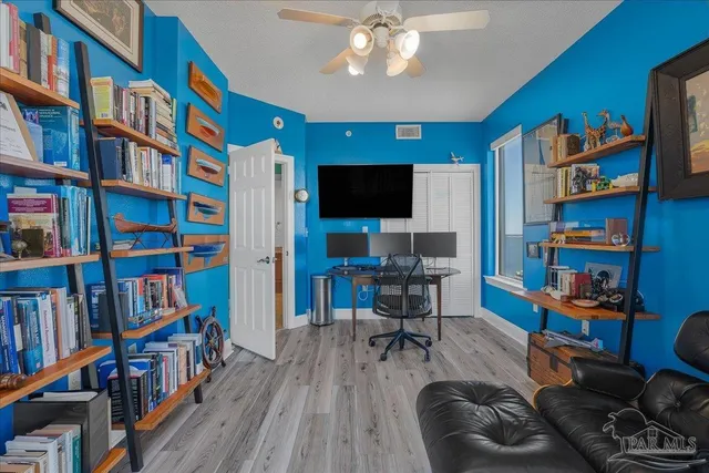 a view of a livingroom with workspace and a bookshelf