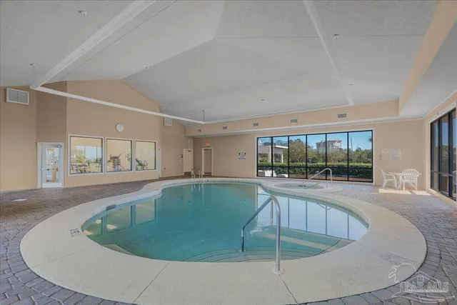 a view of a living room with a fireplace and large windows