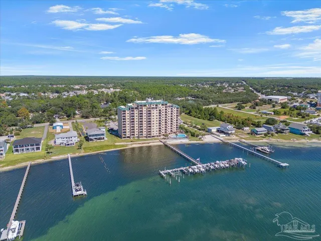 an aerial view of a city with lots of residential buildings ocean and mountain view in back