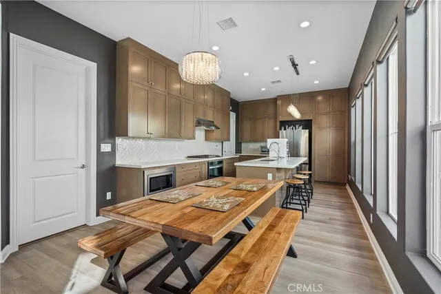 a large kitchen with kitchen island a large counter top space a sink stainless steel appliances and cabinets