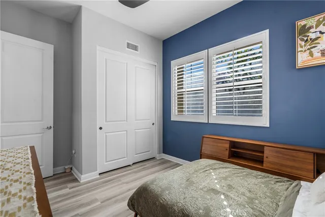 a bedroom with bed tv and wooden floor