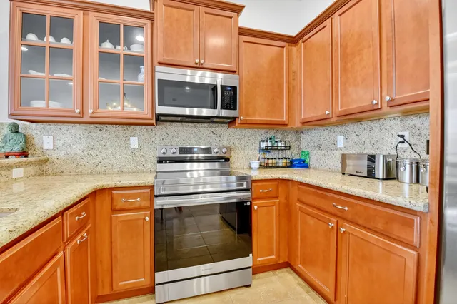 a kitchen with stainless steel appliances granite countertop a stove sink and cabinets