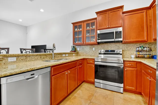 a kitchen with stainless steel appliances granite countertop a sink stove and microwave
