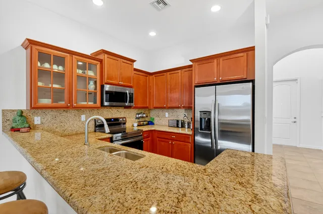 a kitchen with stainless steel appliances granite countertop a stove microwave and sink