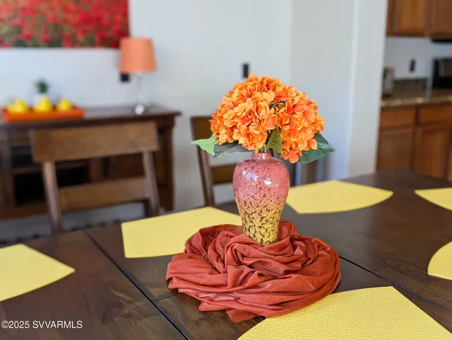 a living room with furniture and a dining table with wooden floor