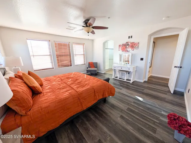 a living room with couches and kitchen view with wooden floor