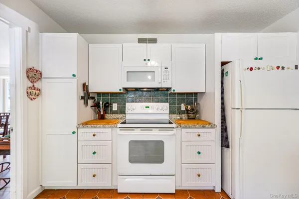 a kitchen with white cabinets and white stainless steel appliances