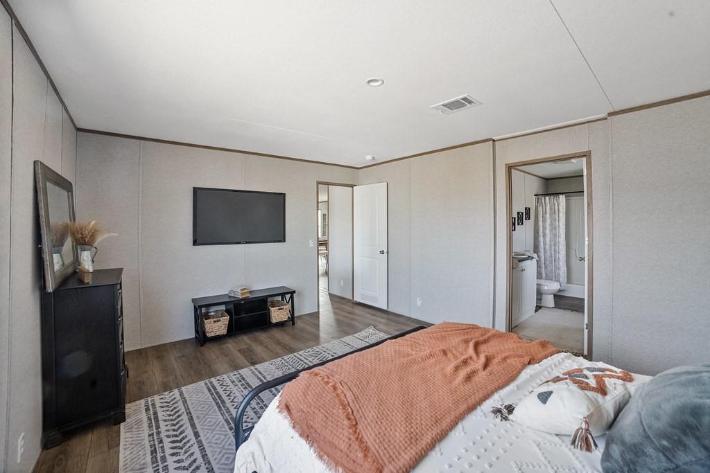 300 Huddleston Road Sunset, TX 76270 - Photo 27 of 40 a bedroom with a bed and wooden floor