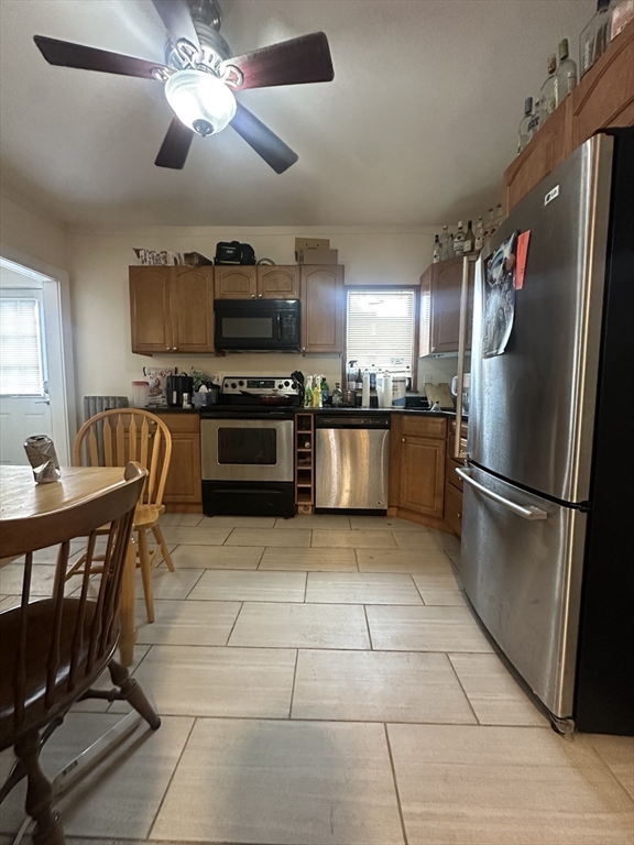 22 Winslow Road Brookline, MA 02446 - Photo 7 of 25 a kitchen with stainless steel appliances granite countertop a stove top oven a refrigerator a dining table and chairs with wooden floor