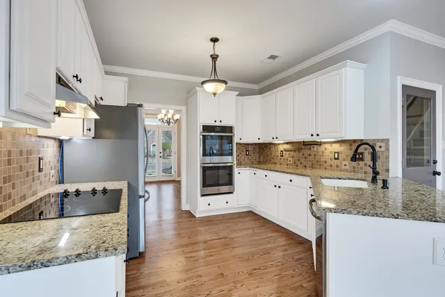 a kitchen with stainless steel appliances granite countertop a sink refrigerator and cabinets