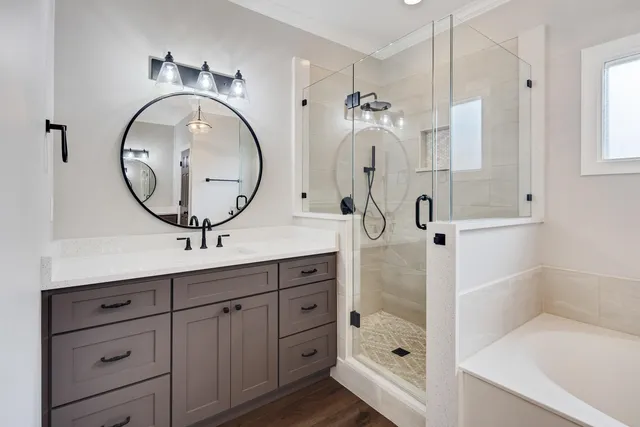 a bathroom with a tub sink and mirror