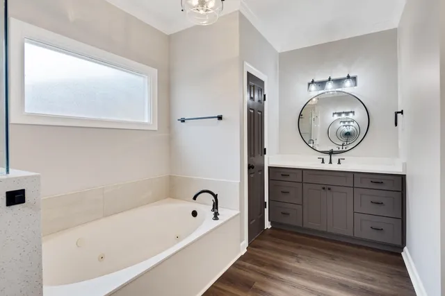 a spacious bathroom with a bathtub sink and mirror