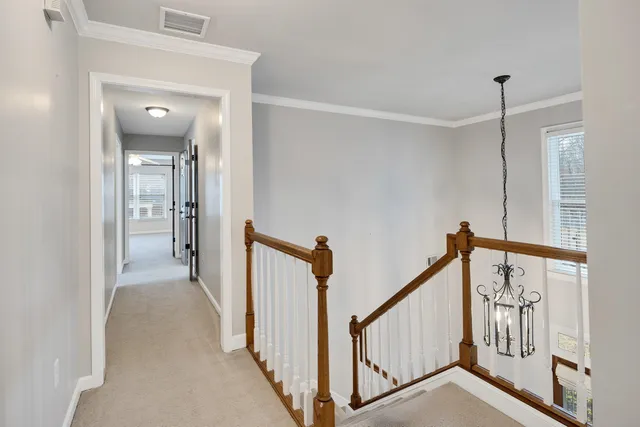 a view of a hallway with wooden floor and stairs