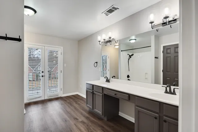 a bathroom with a sink double vanity granite and a mirror