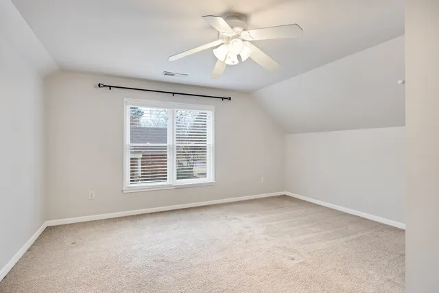 an empty room with a window and a ceiling fan