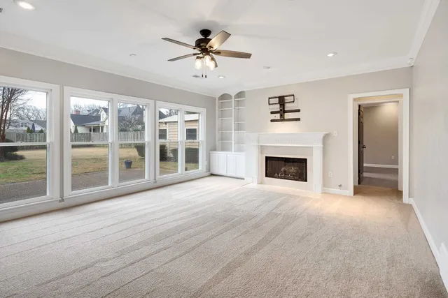 a view of an empty room with a fireplace and a window