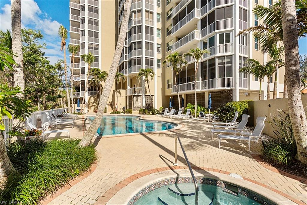 6573 Marissa Loop, Unit 903 Naples, FL 34108 - Photo 17 of 25 a view of a swimming pool with a lounge chairs