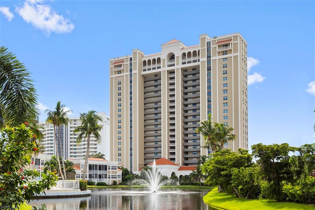 6573 Marissa Loop, Unit 903 Naples, FL 34108 - Photo 19 of 25 a view of a tall building with a yard in front of it