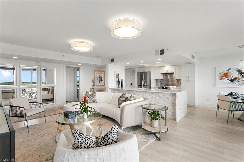 6573 Marissa Loop, Unit 903 Naples, FL 34108 - Photo 2 of 25 a living room with furniture and a dining table with kitchen view