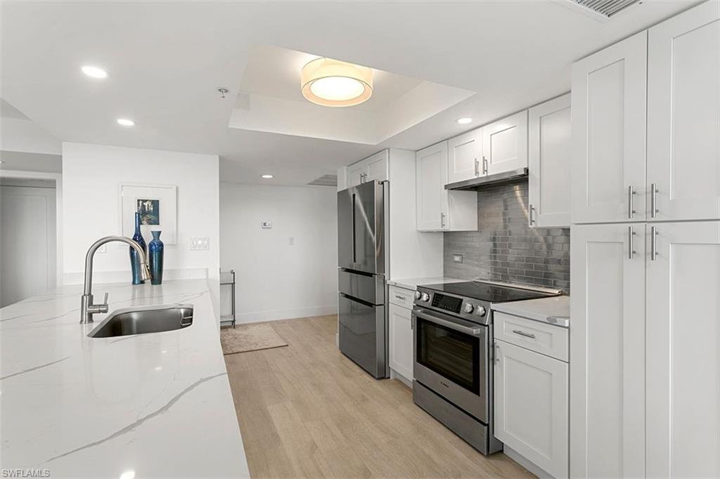 6573 Marissa Loop, Unit 903 Naples, FL 34108 - Photo 4 of 25 a kitchen with stainless steel appliances a refrigerator sink and stove