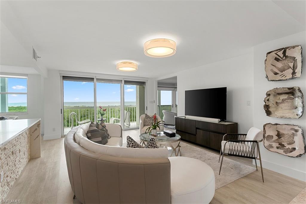 6573 Marissa Loop, Unit 903 Naples, FL 34108 - Photo 5 of 25 a living room with furniture and a flat screen tv