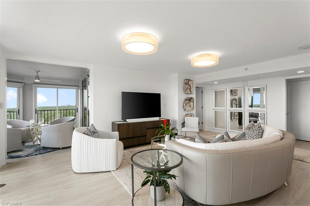 6573 Marissa Loop, Unit 903 Naples, FL 34108 - Photo 6 of 25 a living room with furniture and a flat screen tv