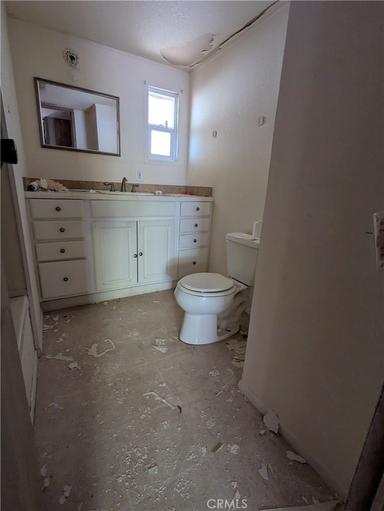 10200 Johnson Road, Unit 36 Phelan, CA 92371 - Photo 13 of 22 a bathroom with a toilet a sink a vanity and mirror