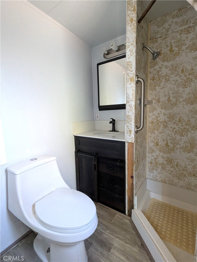10200 Johnson Road, Unit 36 Phelan, CA 92371 - Photo 17 of 22 a bathroom with a toilet sink and mirror