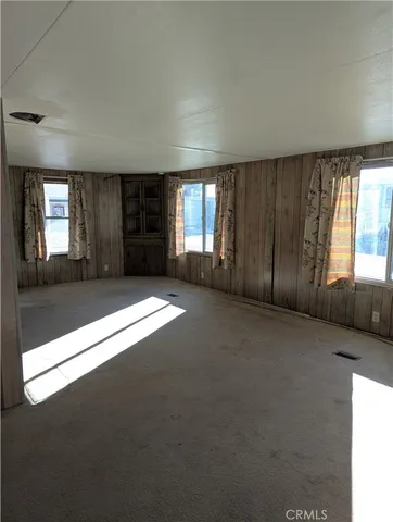 a view of an empty room with window and stairs