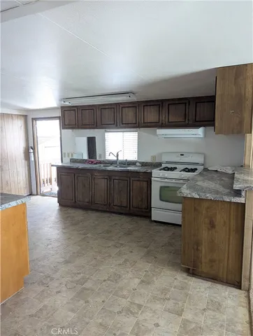 a kitchen with granite countertop a sink a window and cabinets