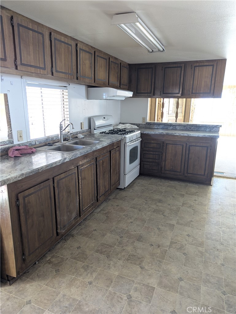 10200 Johnson Road, Unit 36 Phelan, CA 92371 - Photo 10 of 22 a kitchen with granite countertop a sink a window and cabinets