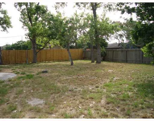 a view of backyard with wooden fence