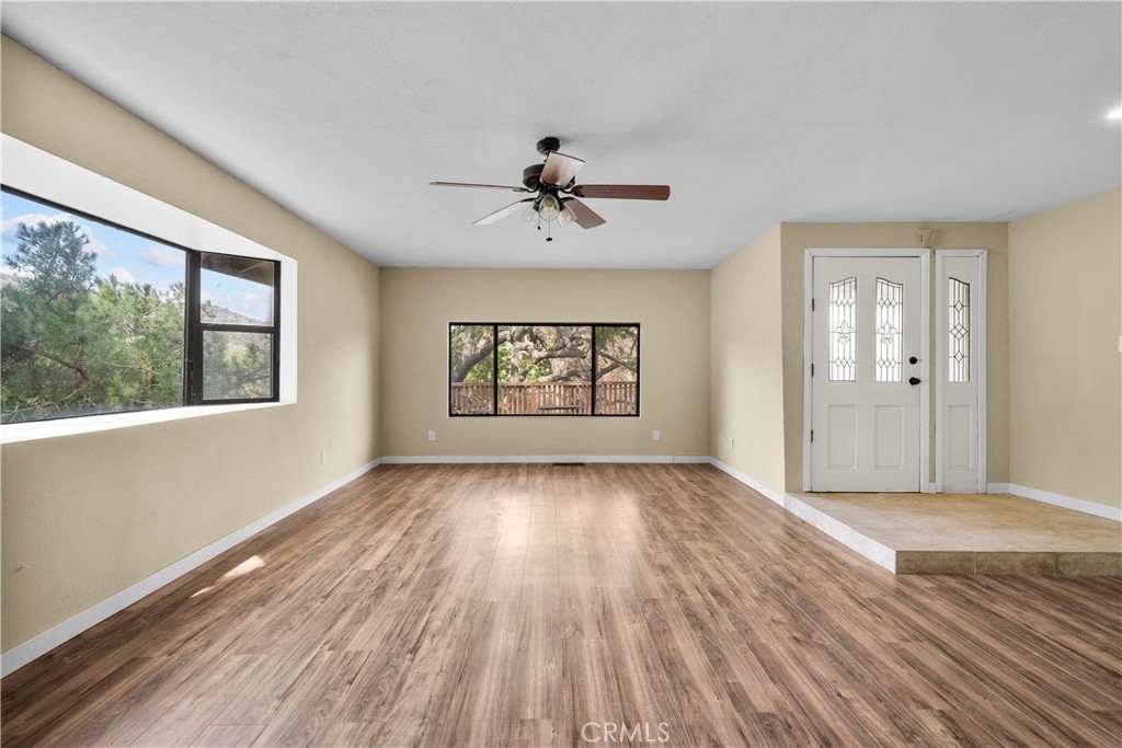 29570 Butterfield Way Tehachapi, CA 93561 - Photo 12 of 50 a view of an empty room with a window and wooden floor