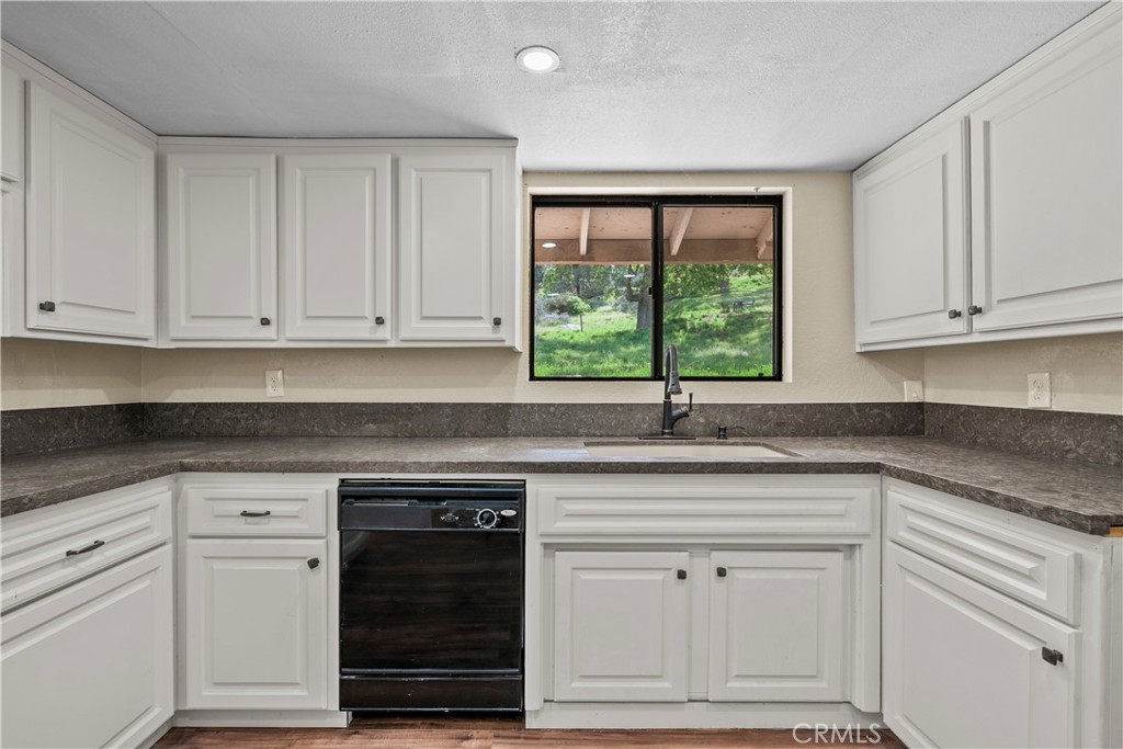 29570 Butterfield Way Tehachapi, CA 93561 - Photo 16 of 50 a kitchen with white cabinets and a window