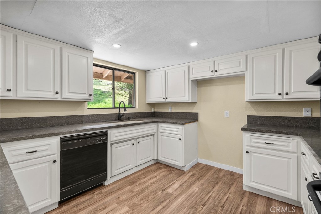 29570 Butterfield Way Tehachapi, CA 93561 - Photo 19 of 50 a kitchen with granite countertop white cabinets and white appliances