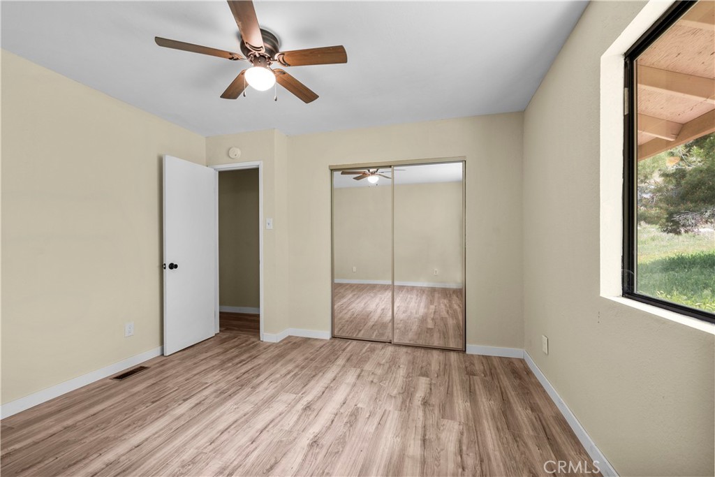 29570 Butterfield Way Tehachapi, CA 93561 - Photo 31 of 50 an empty room with wooden floor fan and windows
