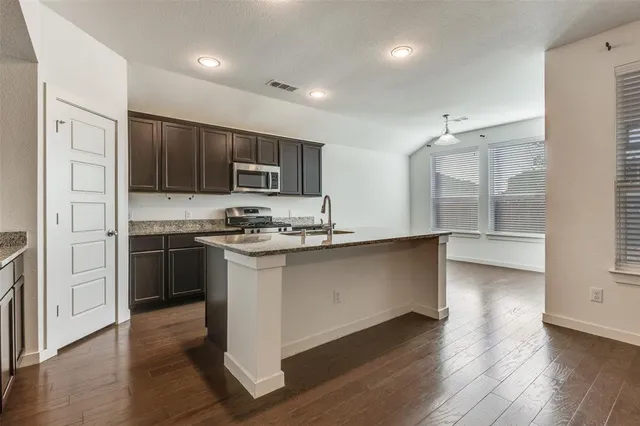 a kitchen with kitchen island a counter top space a sink and appliances