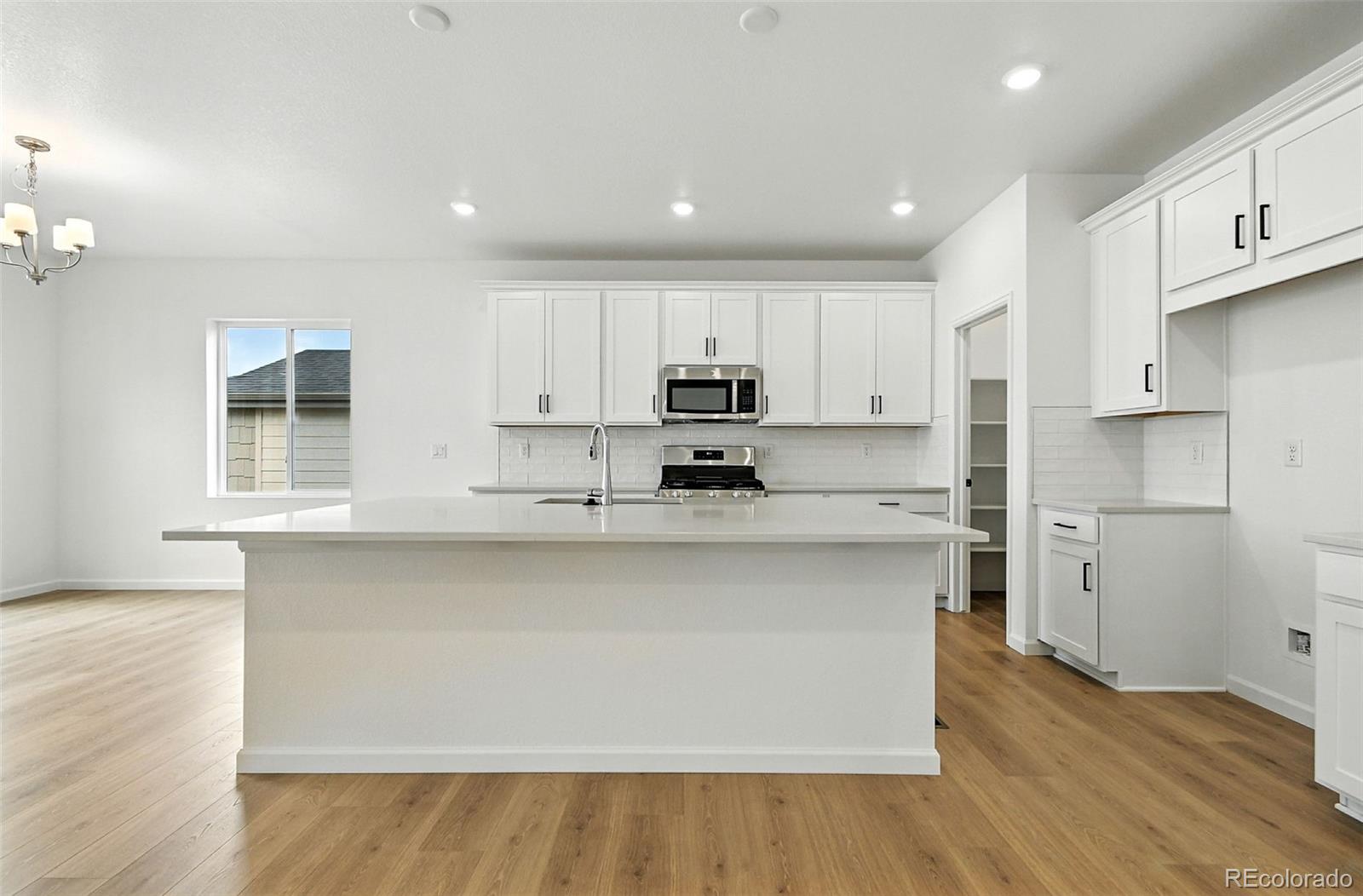 17075 West 92nd Loop Arvada, CO 80007 - Photo 14 of 33 a kitchen with stainless steel appliances granite countertop a stove top oven a sink and white cabinets