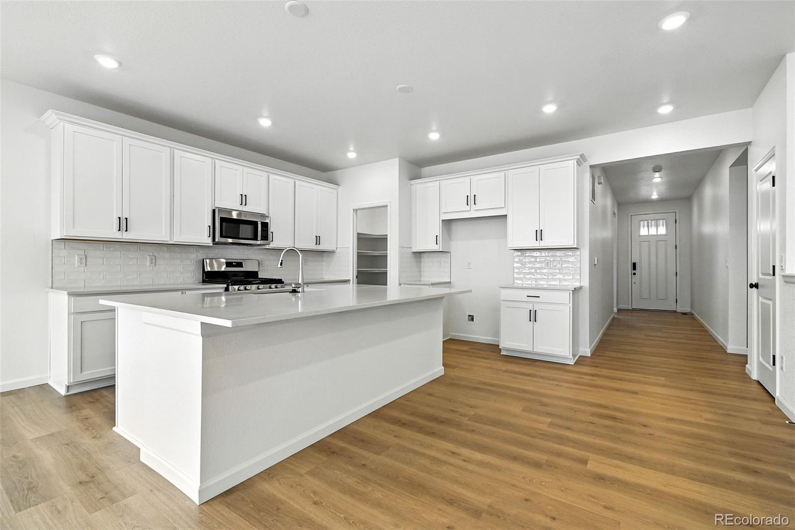 17075 West 92nd Loop Arvada, CO 80007 - Photo 15 of 33 a kitchen with white cabinets and stainless steel appliances