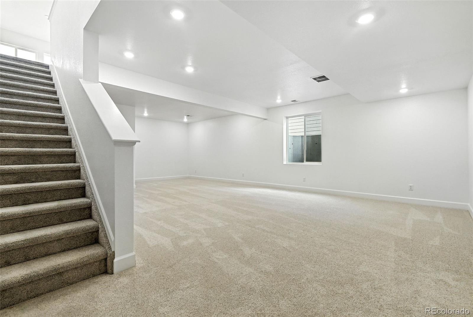 17075 West 92nd Loop Arvada, CO 80007 - Photo 24 of 33 an empty room with stairs and windows